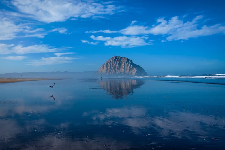 Reflection of Morro Rock at the beach