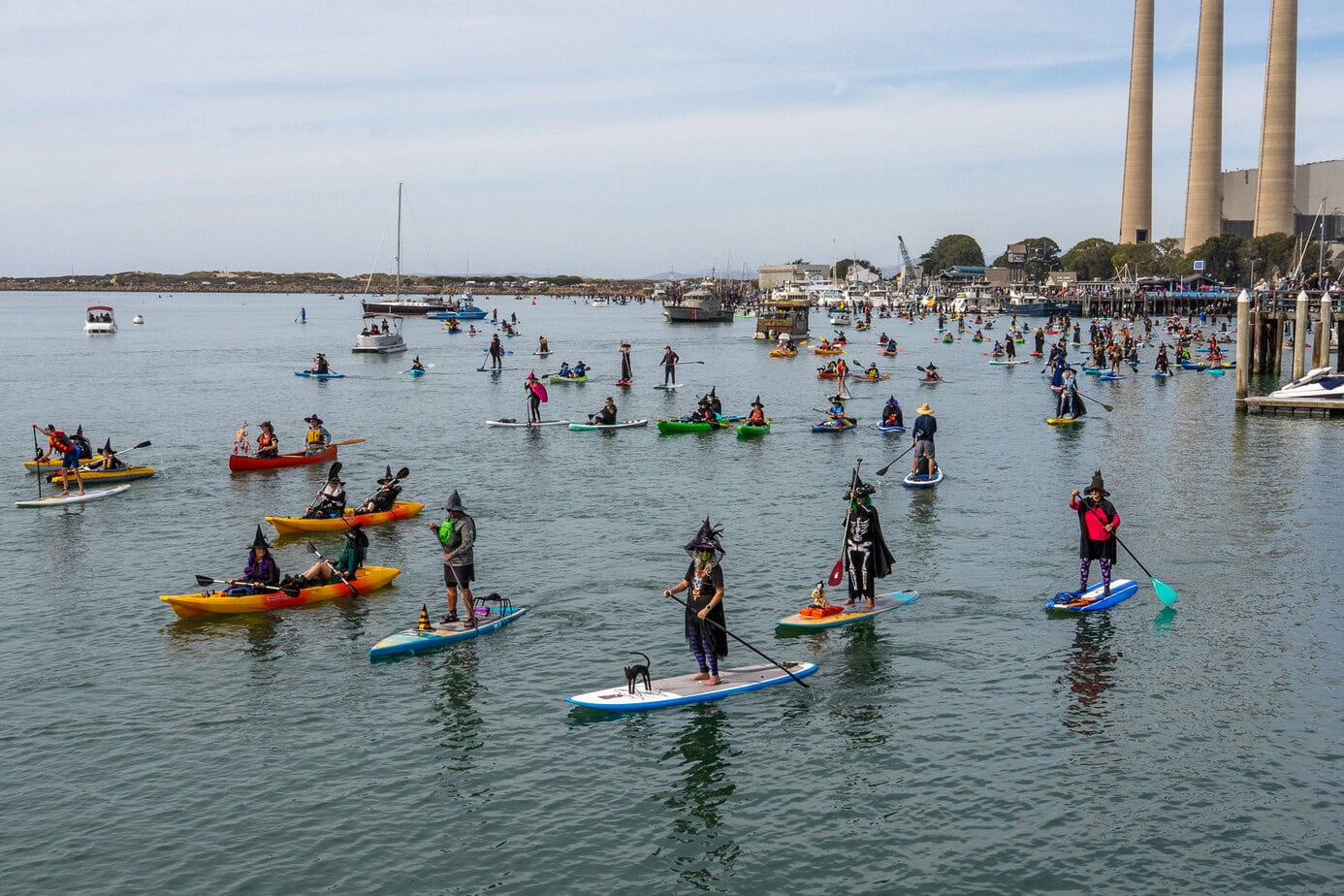 Large group of costumed paddlers on Morro Bay near the Embarcadero during the annual Witches Paddle