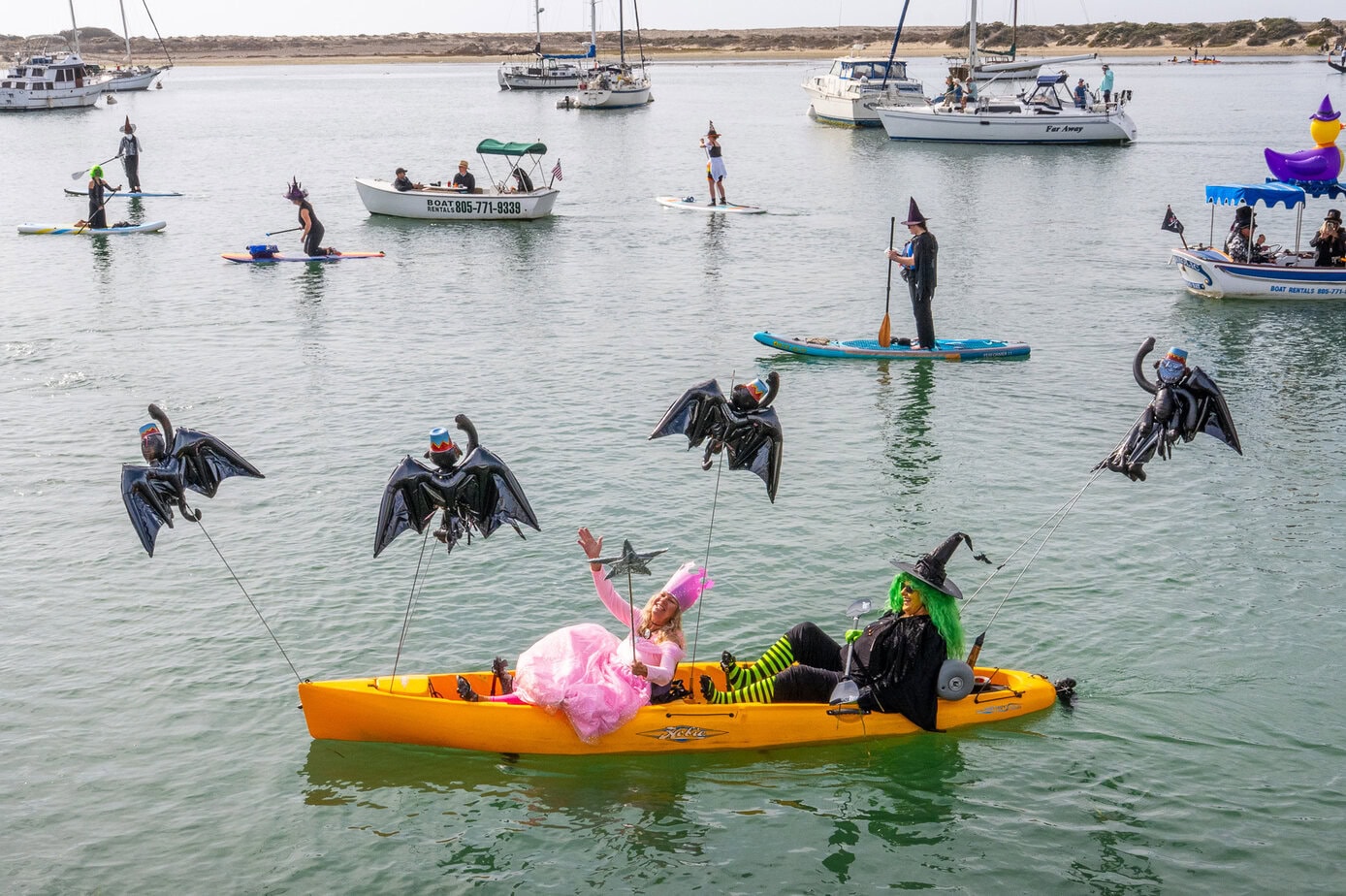 Halloween-themed decorated kayak and costumed paddlers participating in the Morro Bay Witches Paddle