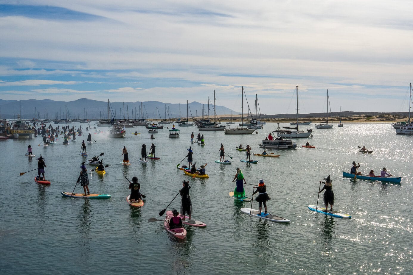 Large group of kayakers and paddleboarders in costume on Morro Bay during the Halloween paddle