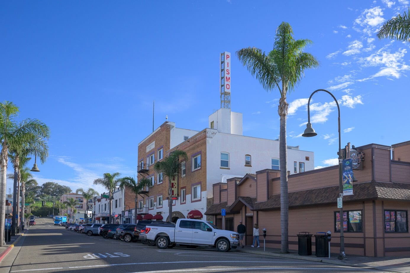 Downtown Pismo Beach with shops, palm trees, and coastal town atmosphere