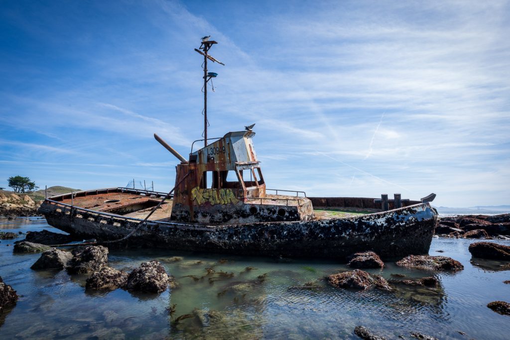 Weathered Point Estero shipwreck surrounded by rocks and tidepools near Cayucos, California.