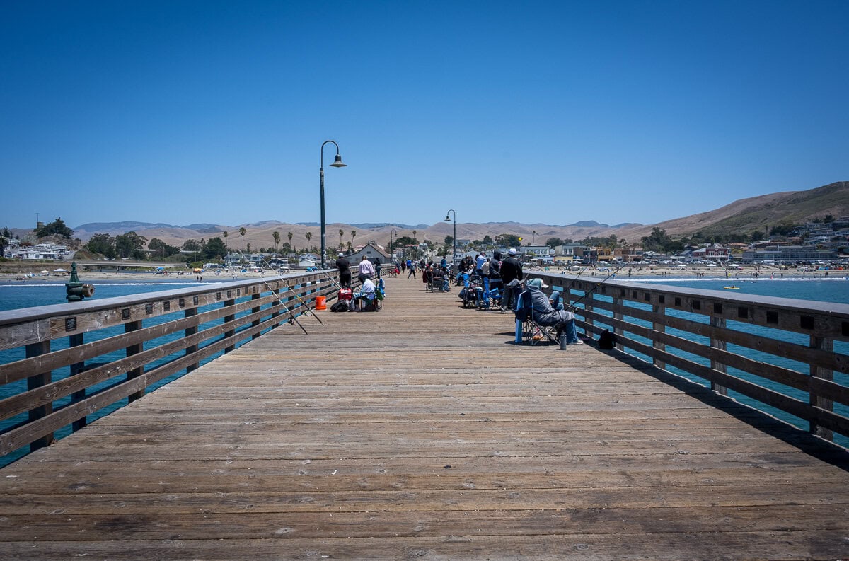 View along the wooden pier toward the town of Cayucos and the coastal hills