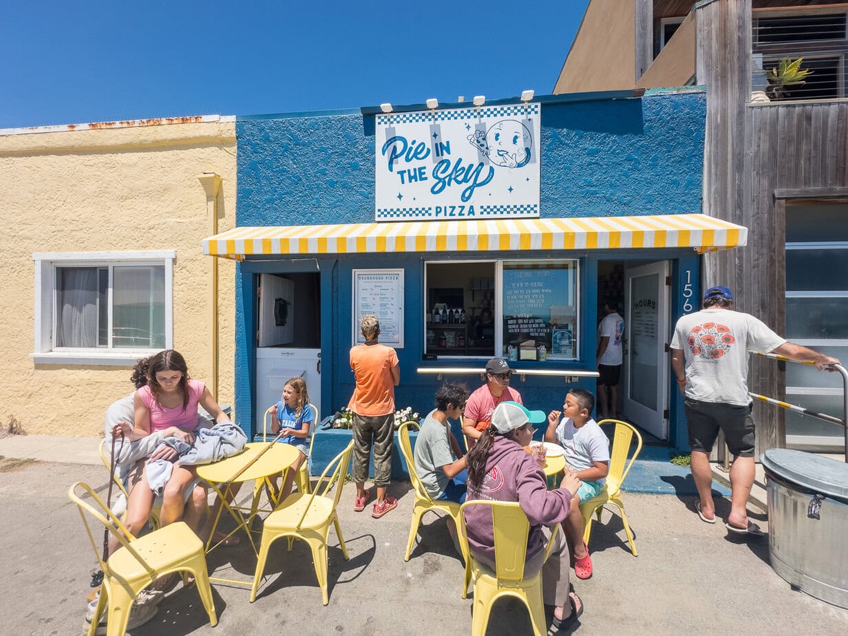 People sitting outside Pie in the Sky pizza near the beach in Cayucos.